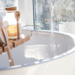 white bathtub with wood accessories