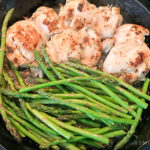 asparagus and herb chicken thighs in iron skillet