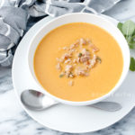butternut squash soup in white bowl with sage