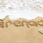 Grenada written in sand with ocean waves