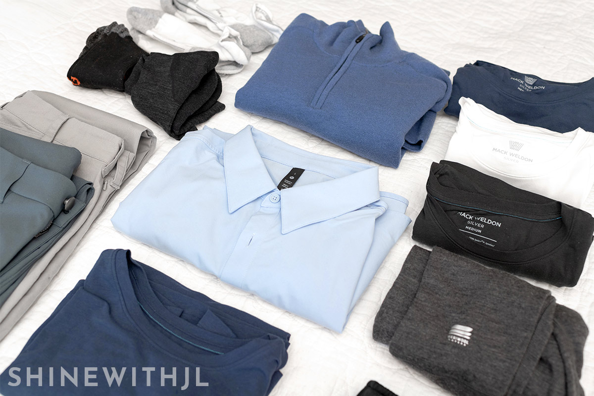 Flatlay of men’s Italy spring capsule wardrobe including tops, bottoms, shoes, and layering pieces for March and April travel.
