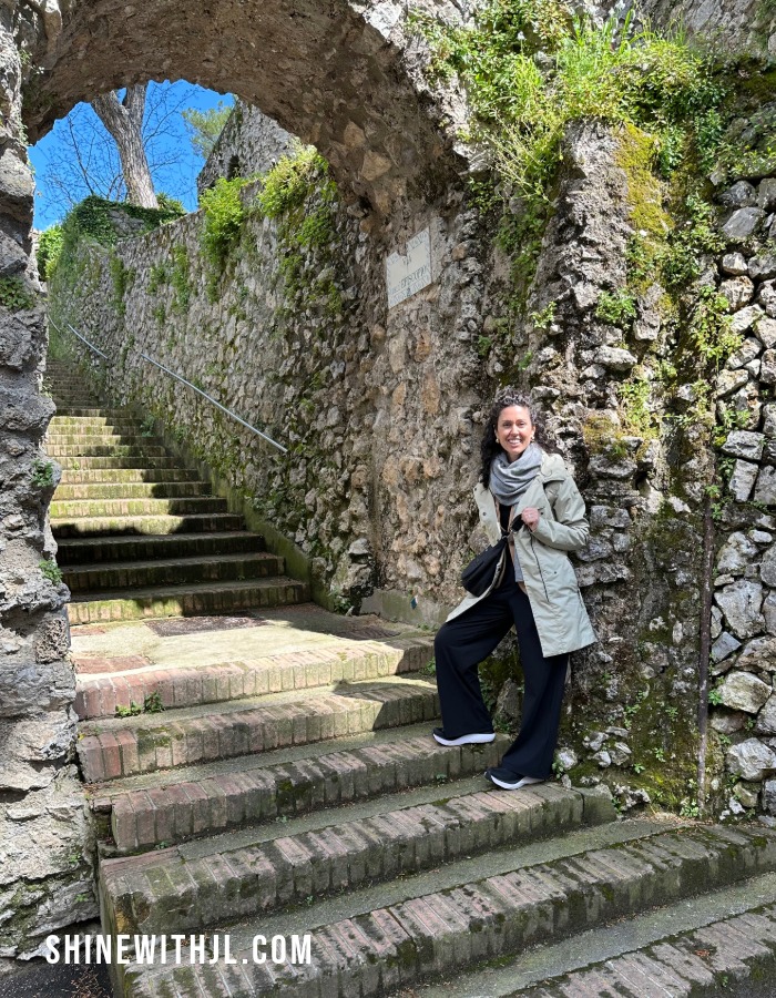 Walking Stone Steps in Ravello Wearing a Waterproof Trench Coat Petite woman walking up stone steps in Ravello, Italy, wearing a waterproof trench coat, showing coverage and comfort for long sightseeing days