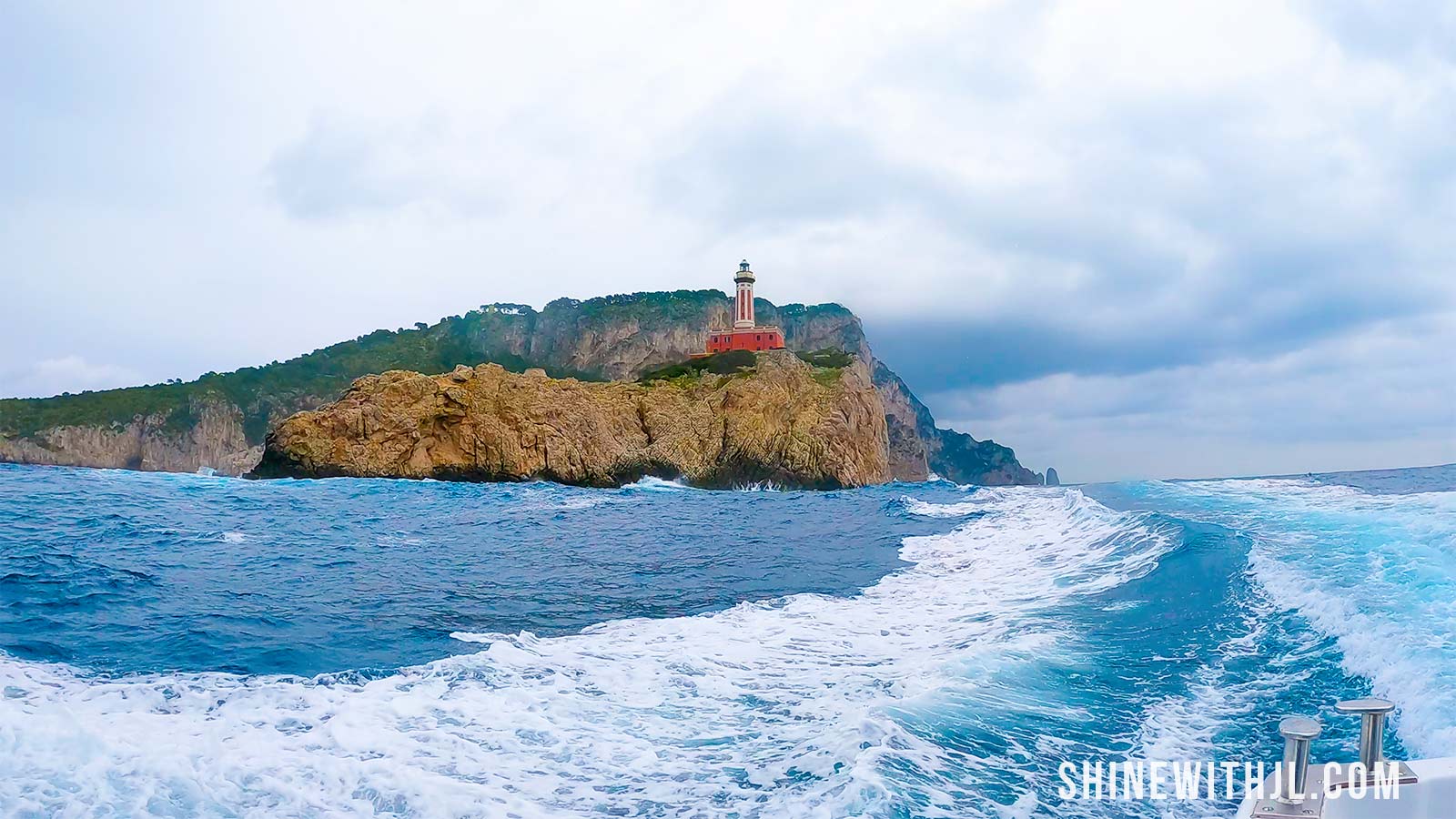 View from a boat tour around Capri in March showing rough seas and the island coastline under gray skies.